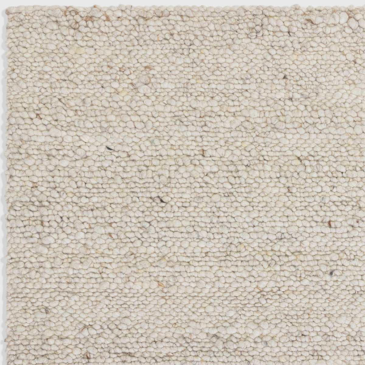Alvo Rugs Adio ivory wool rug featuring a chunky hand-woven boucle loop pile texture in soft cream tones.