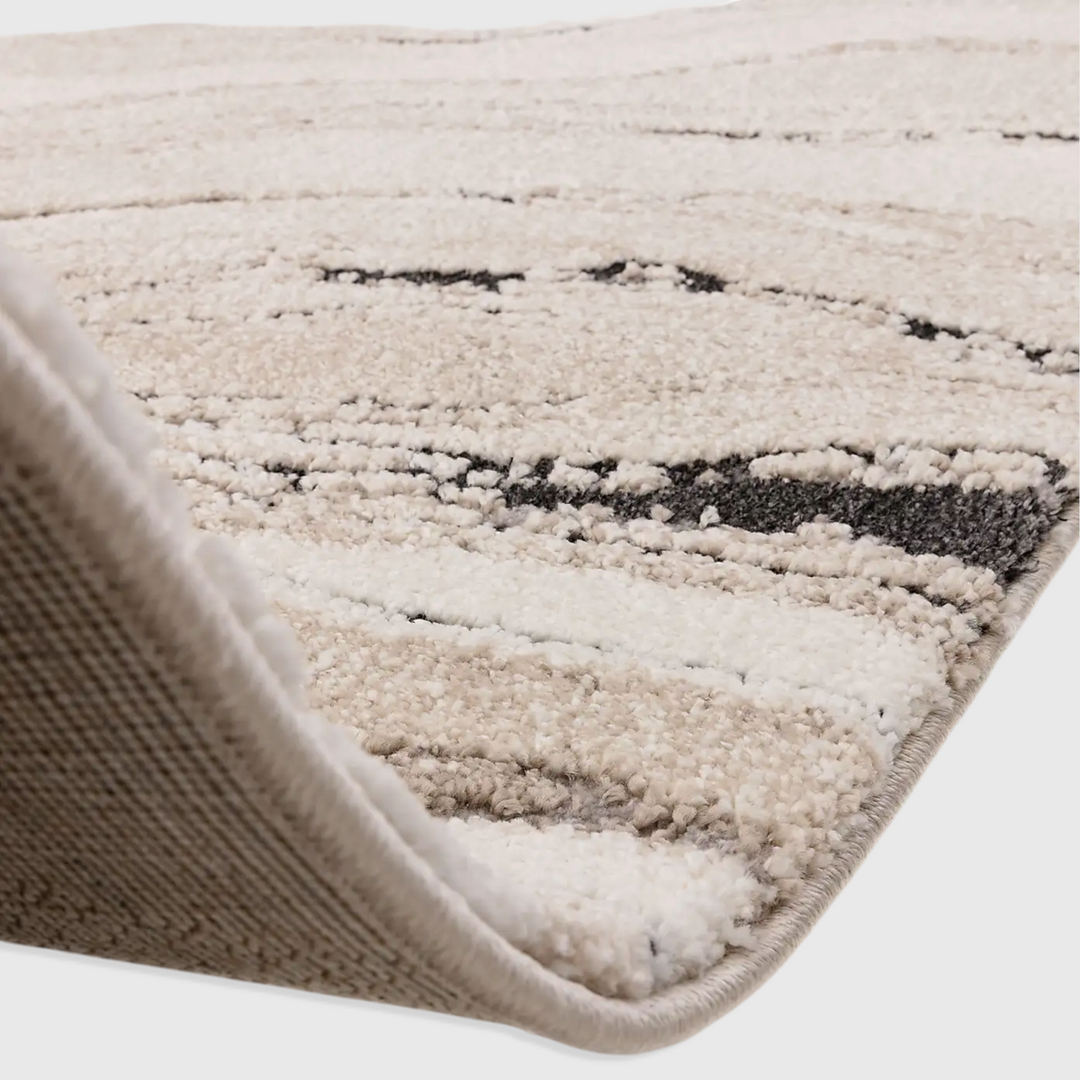 Alvo Rugs Miraga Quartz beige shaggy rug with high-low pile and abstract natural patterns, showing jute backing detail.