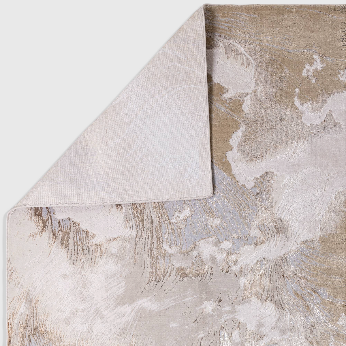 Alvo Rugs Aurorella Etch Au23 abstract rug in gold and beige with a folded corner showing the cotton backing