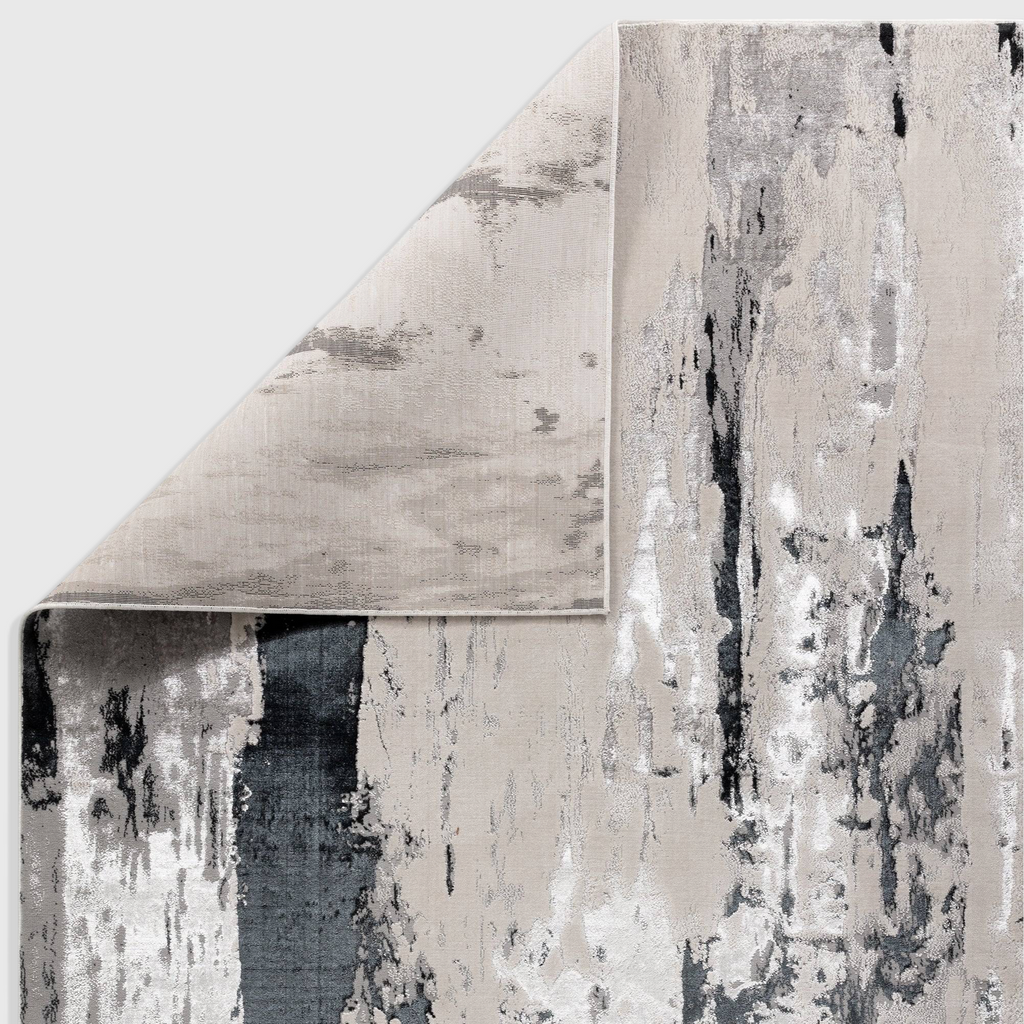 Alvo Rugs Aurorella Au10 Glacier abstract area rug in grey and silver with a folded corner showing jute backing