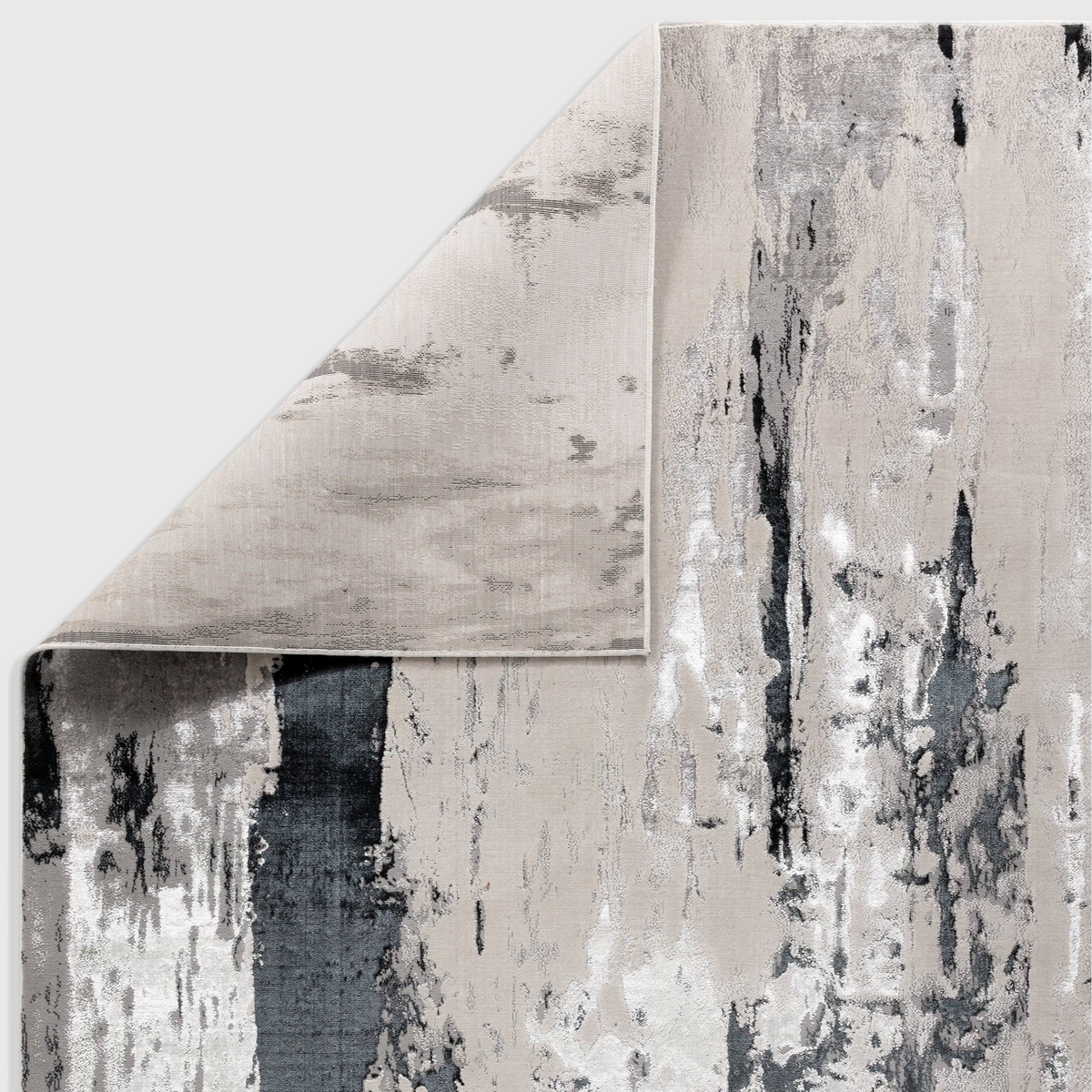 Alvo Rugs Aurorella Au10 Glacier abstract area rug in grey and silver with a folded corner showing jute backing