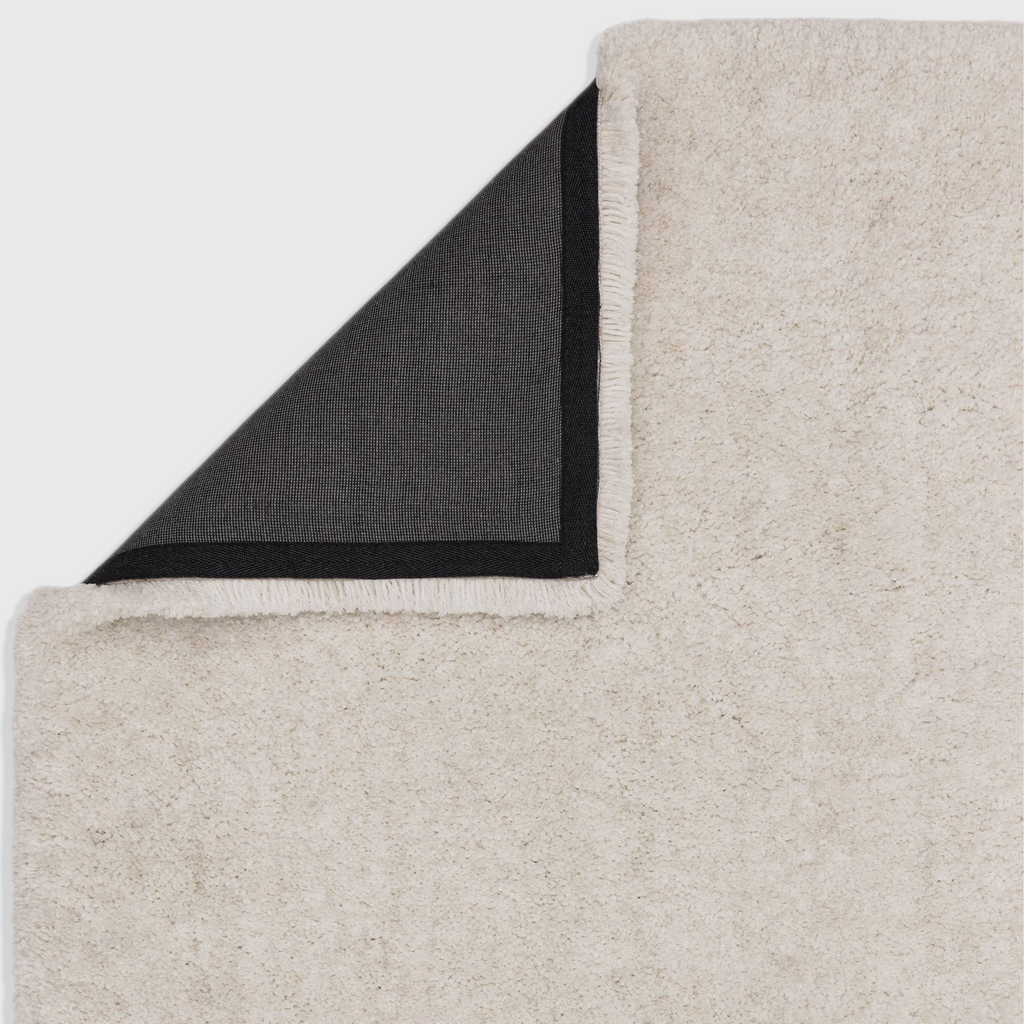 Alvo Rugs Barnett off white shaggy rug with deep pile and black latex backing shown from the corner