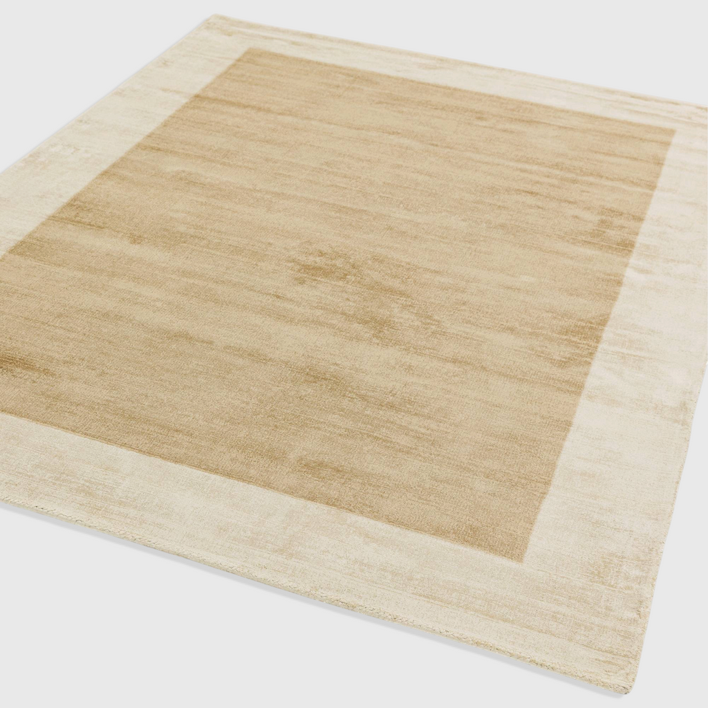 Alvo Rugs Blayde handwoven viscose rug in putty and champagne with a contrasting border and tip-sheared texture.