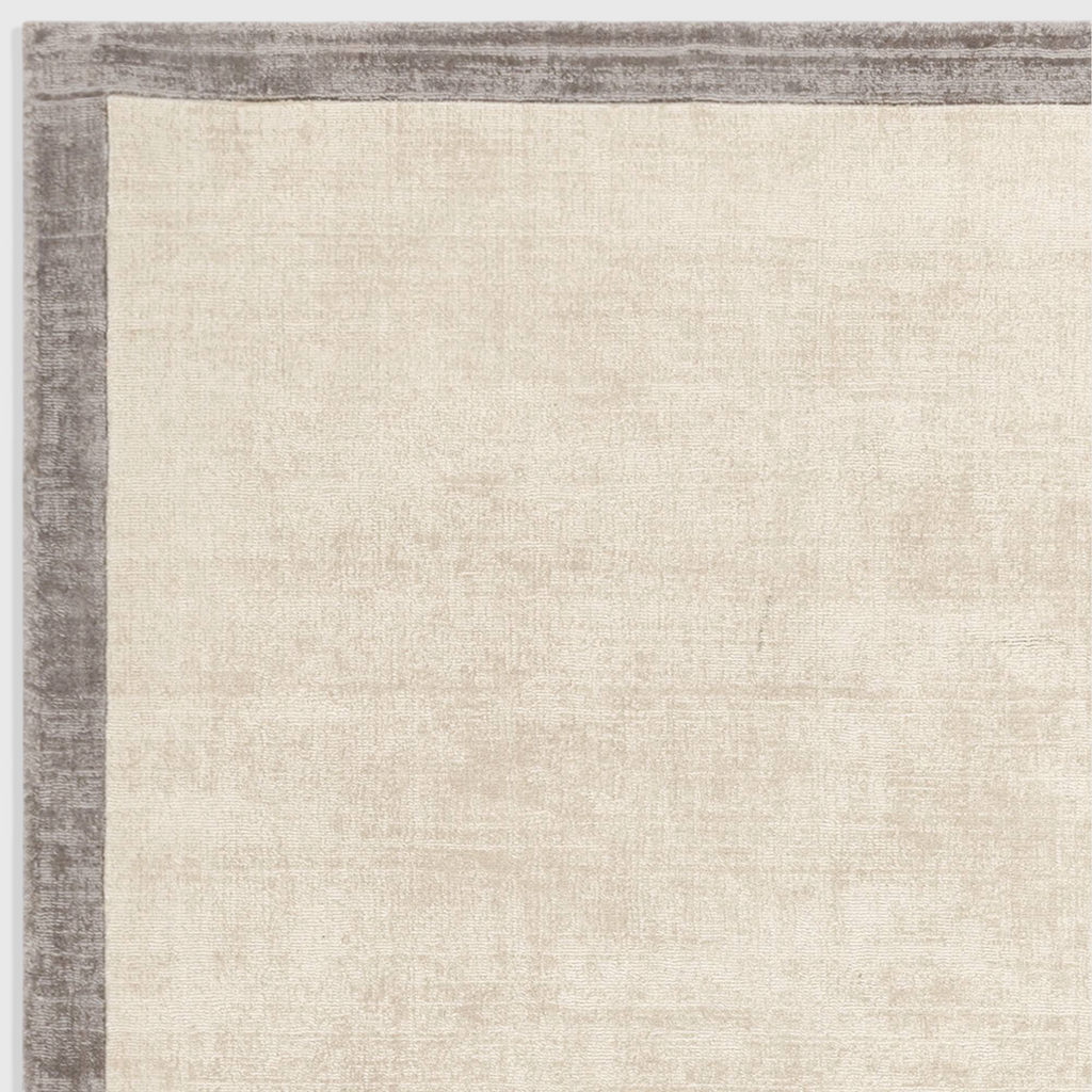 Alvo Rugs Blayde hand-woven viscose rug in putty and silver with a contrasting dark border and tip-sheared texture.