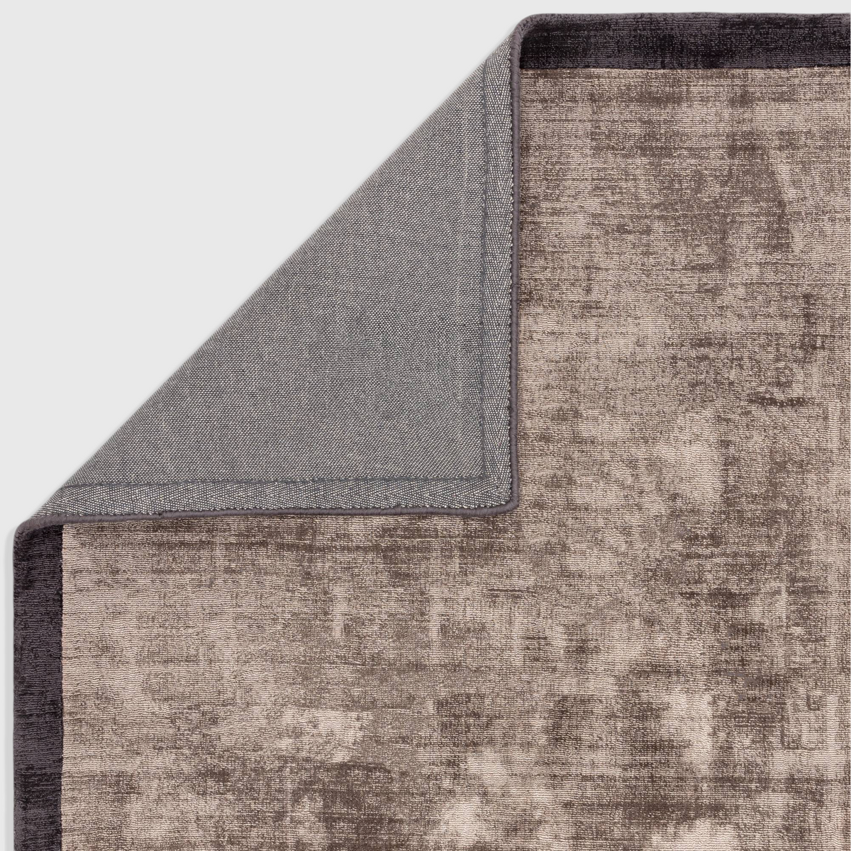 Alvo Rugs Blayde charcoal and moleskin viscose rug showing the hand-woven texture and grey cotton polyester backing