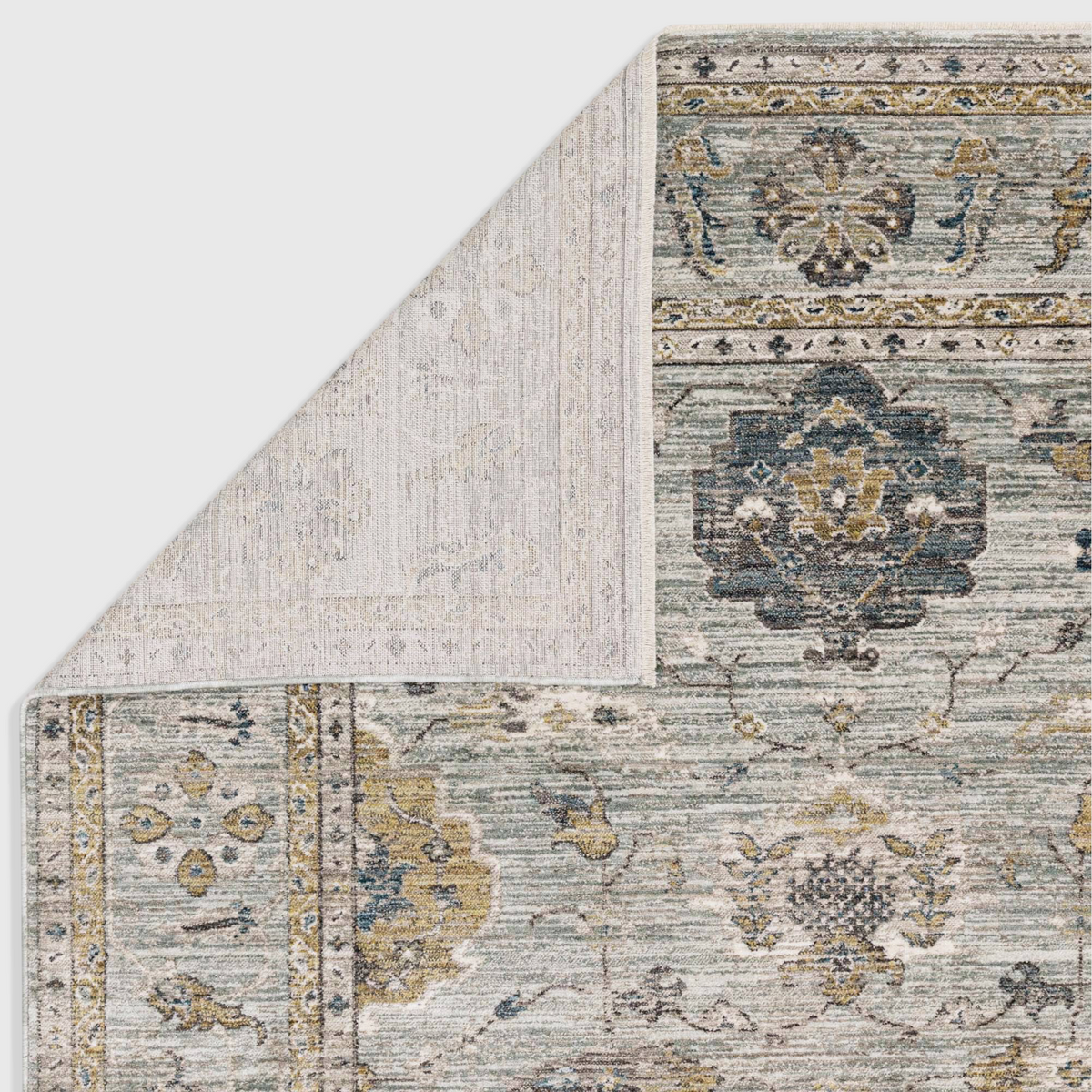 Alvo Rugs Jaspere Ja01 blue polyester rug with a classic antique design and a folded corner showing the backing.