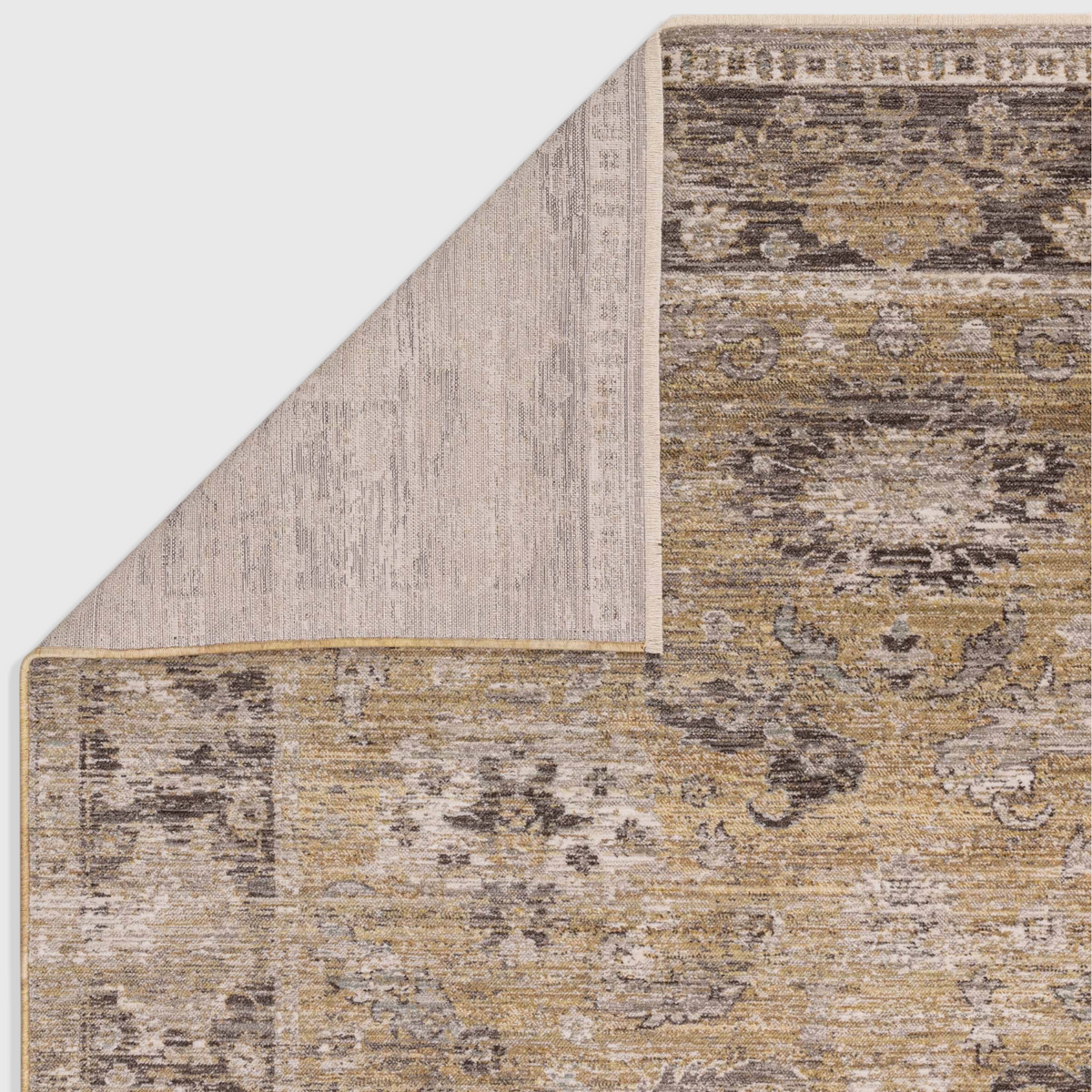 Alvo Rugs Jaspere Ja06 rug showing a corner fold with a neutral cotton backing and antique yellow and grey pattern