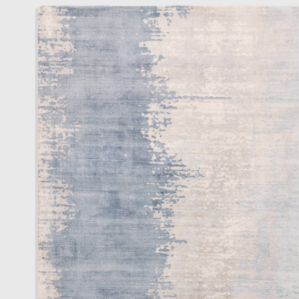 Alvo Rugs Junow aquamarine viscose rug featuring an abstract blue and cream hand-woven design with a soft loop pile.