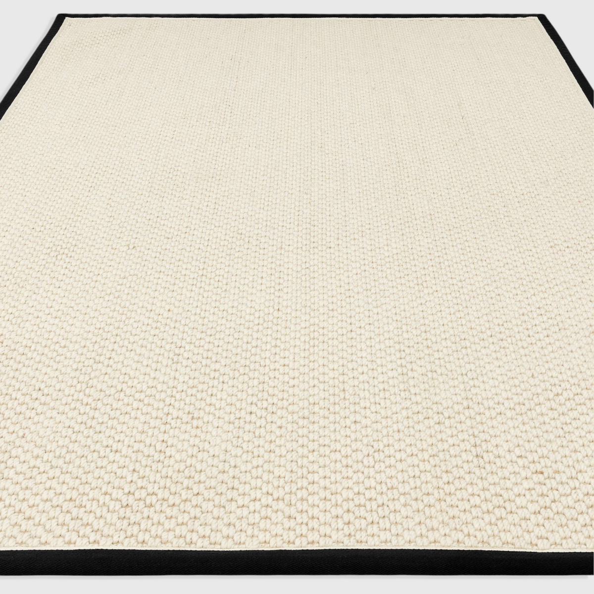 Alvo Rugs Kori charcoal and cream wool and jute rug with a textured double loop pile and a dark cotton border.