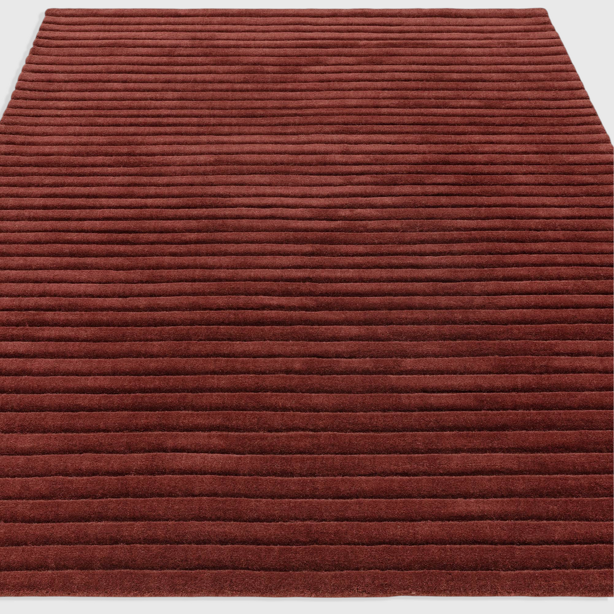 Alvo Rugs Lina burgundy wool rug with a textured high-low ridged pile design for a soft and durable floor covering.