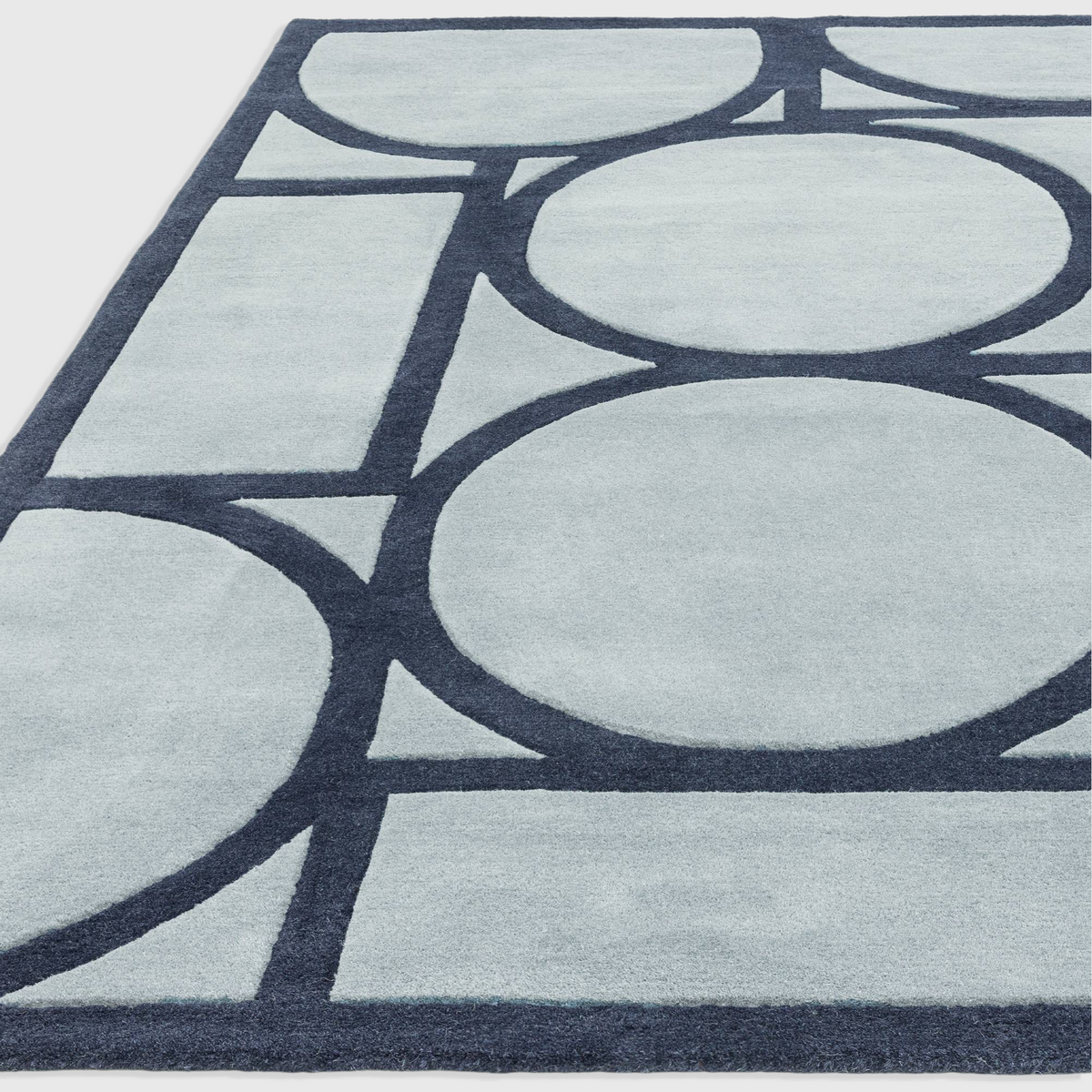 Alvo Rugs Metra blue wool rug featuring a hand-tufted geometric circle pattern with a high-low pile texture.