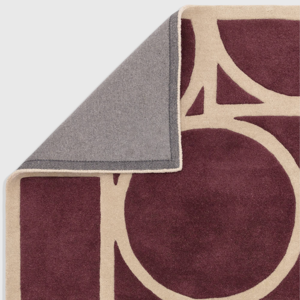 Alvo Rugs Metra Plum wool rug with geometric pattern, showing hand-tufted texture and cotton backing corner detail.