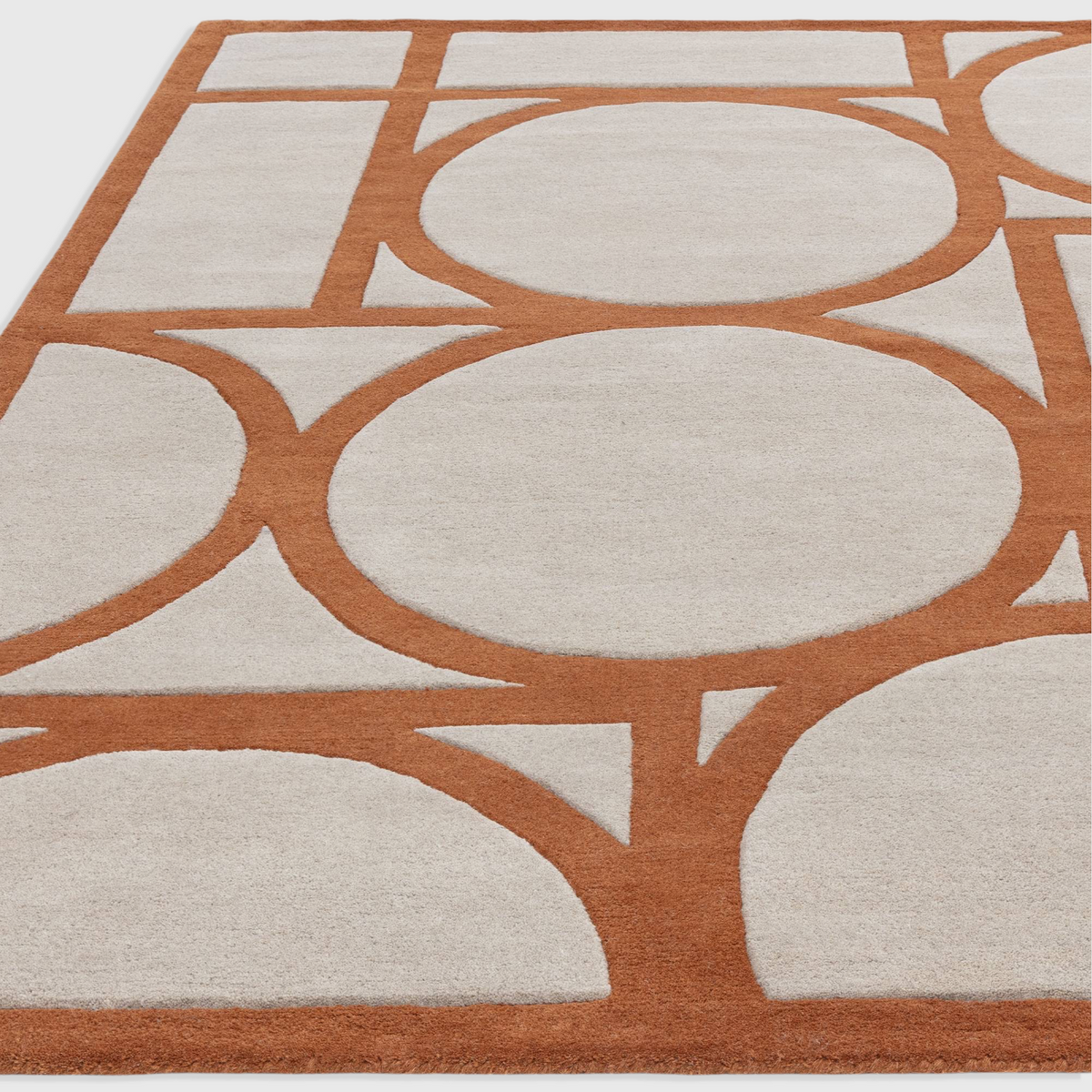 Alvo Rugs Metra rust and cream wool rug with a geometric circle pattern and high-low pile texture.