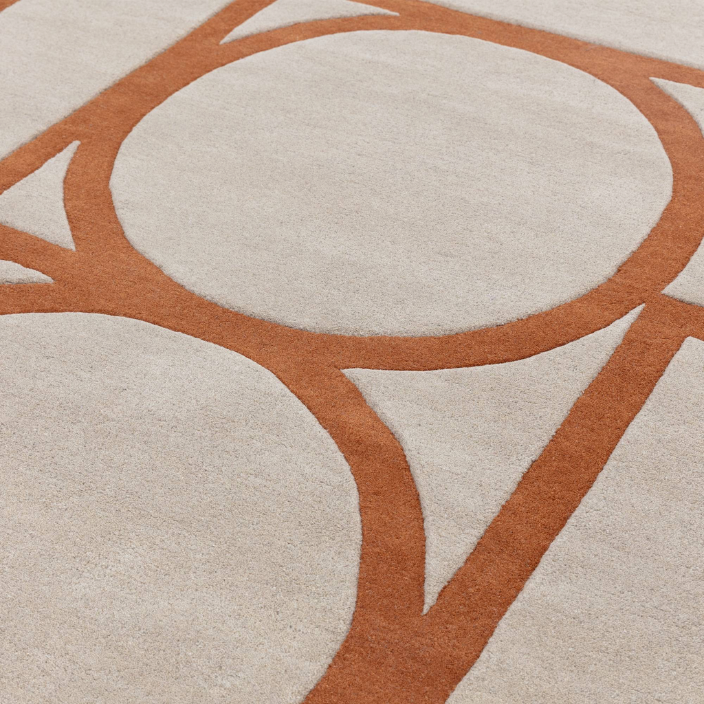 Alvo Rugs Metra rust wool rug featuring a high-low pile geometric circle pattern in orange and cream tones.