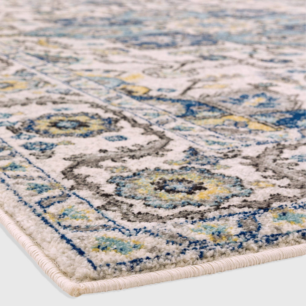 Alvo Rugs Novella Nv25 Persian blue rug with intricate floral patterns in blue, grey, and yellow on a white base.