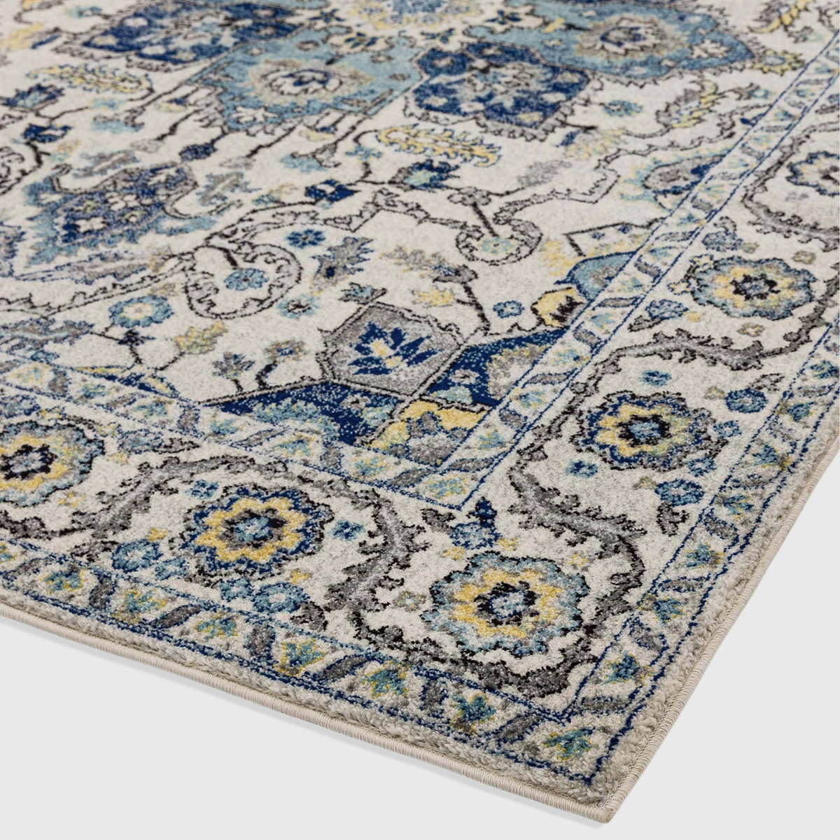 Alvo Rugs Novella Nv25 Persian blue rug with intricate floral patterns in blue, yellow, and grey on a cream background.