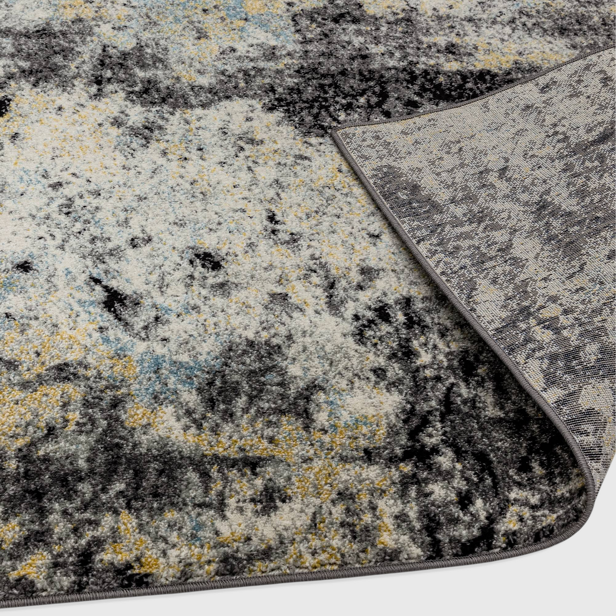 Alvo Rugs Novella Nv32 abstract blue rug with a folded corner showing the durable polypropylene pile and jute backing.